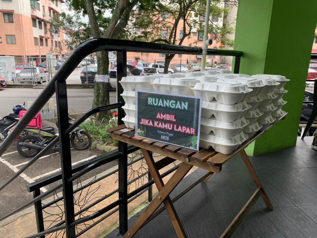 Packets of food provided for those in need are stacked neatly on a table outside Kedai Makan Abang Tukang Masak in Damansara Damai.