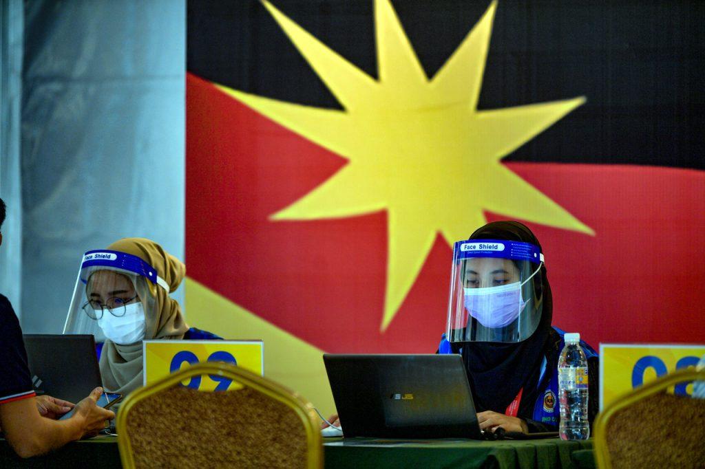 Frontline workers man the registration table at the Klinik Kesihatan Jalan Masjid vaccination centre in Dewan Majma' Kuching. Photo: Bernama