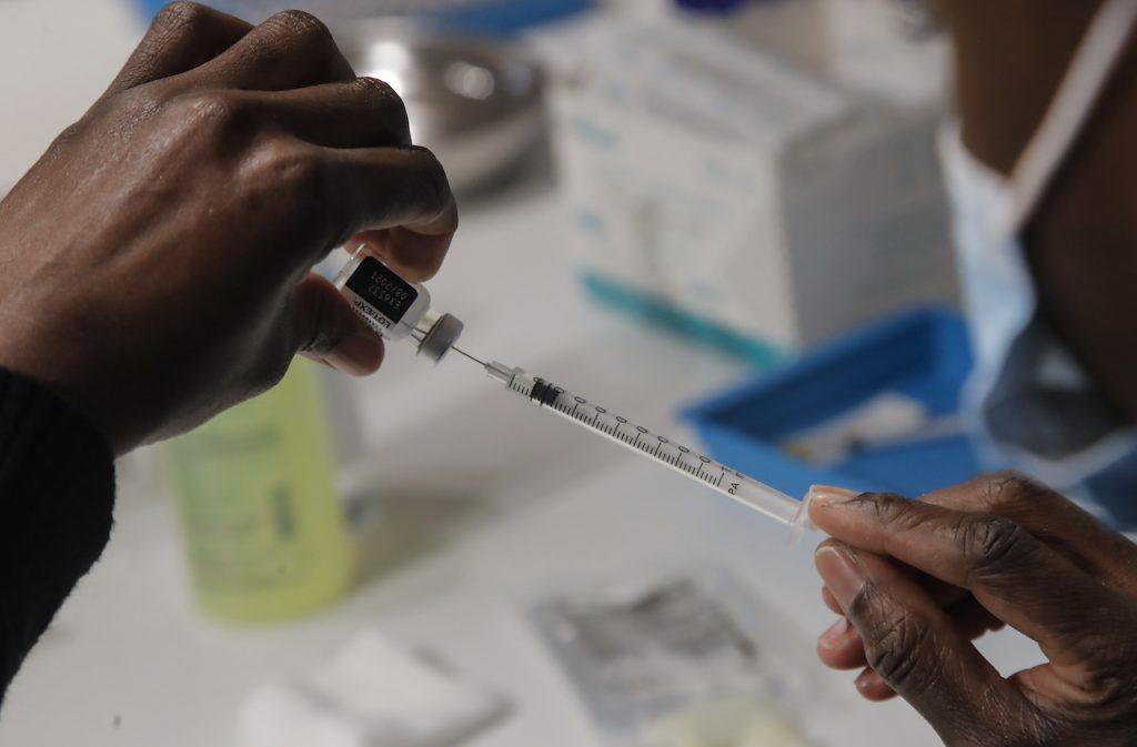 A member of Paris' fire brigade prepares a syringes with the Pfizer Covid-19 vaccine at a vaccination centre in Paris, May 6. Photo: AP