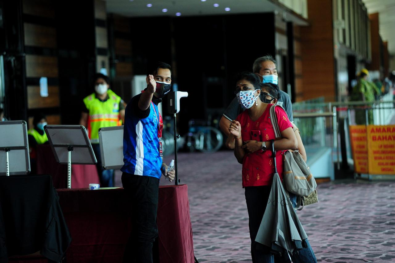 Volunteers direct vaccine recipients at the Ideal Convention Centre in Shah Alam on June 23. Photo: Bernama