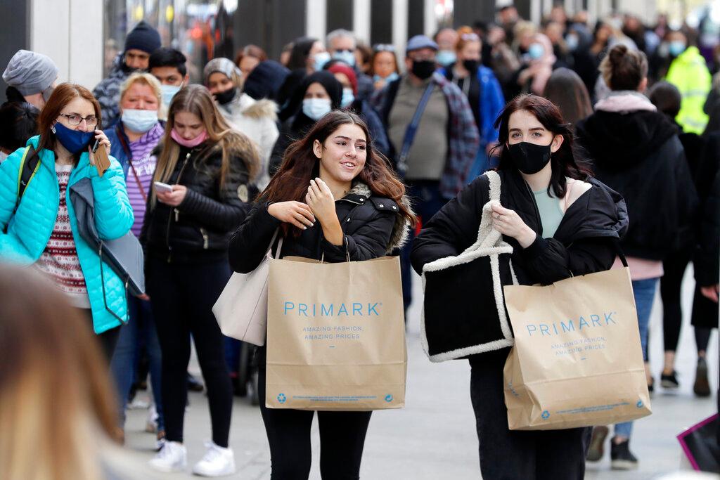 People carry shopping bags while others queue to enter a store on Oxford Street in London, in this April 12 file photo. Photo: AP