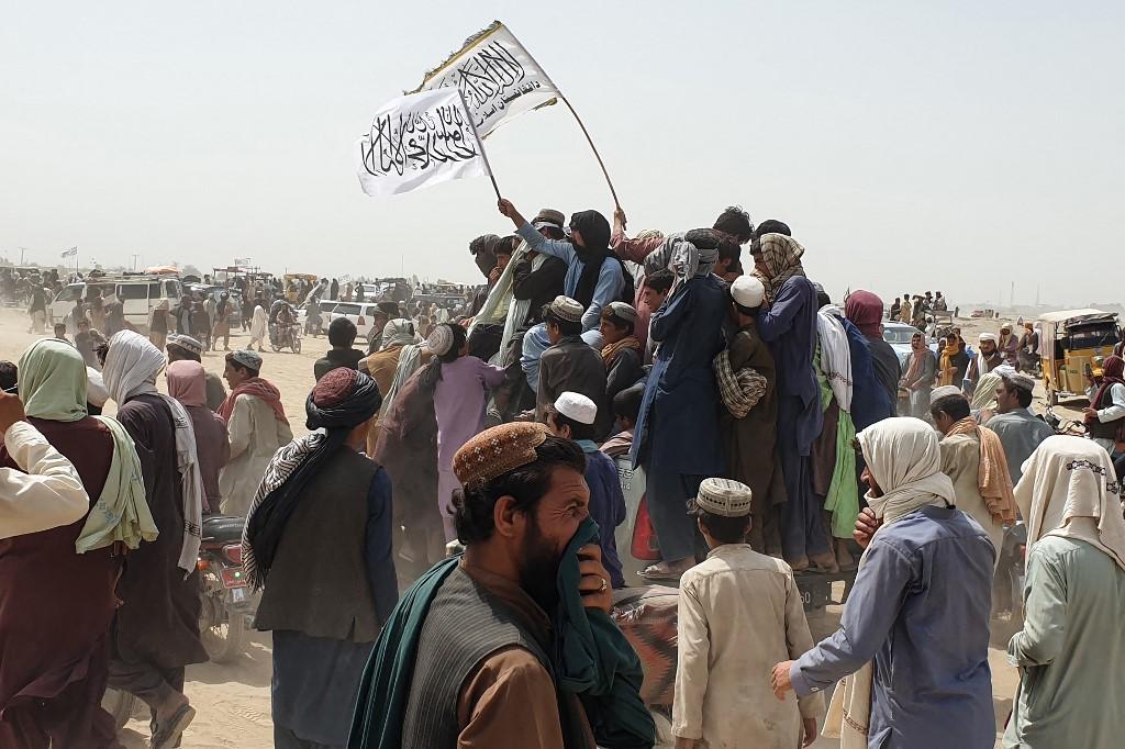 People wave Taliban flags as they drive through the Pakistani border town of Chaman on July 14, after the Taliban claimed they had captured the Afghan side of the border crossing of Spin Boldak along the frontier with Pakistan. Photo: AFP