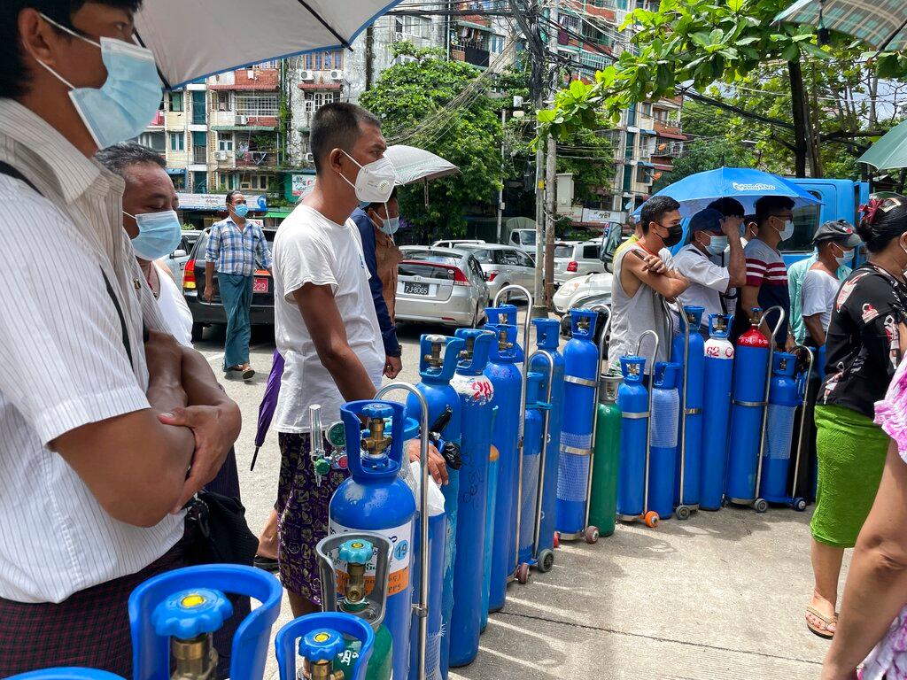 People queue up with their oxygen tanks outside an oxygen refill station in Pazundaung township in Yangon, Myanmar, July 11. Photo: AP
