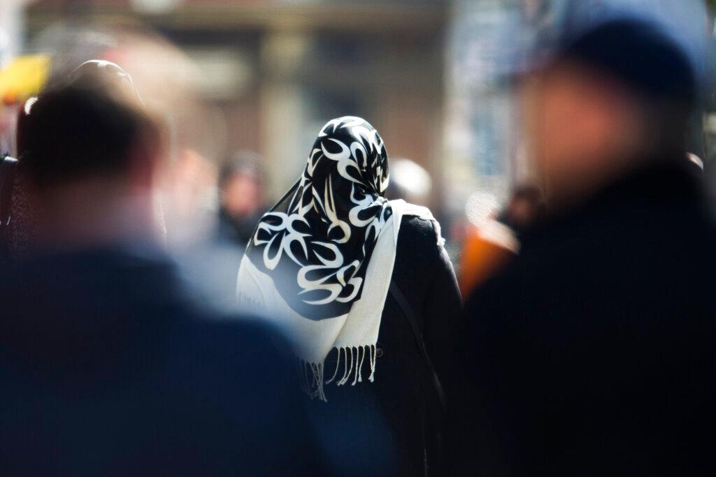 In this March 15, 2013 file photo, a woman wearing a headscarf walks between other people on a street at the district Neukoelln in Berlin. The European Union’s top court ruled July 15 that employers may forbid the wearing of visible symbols of religious or political belief, such as headscarves. Photo: AP