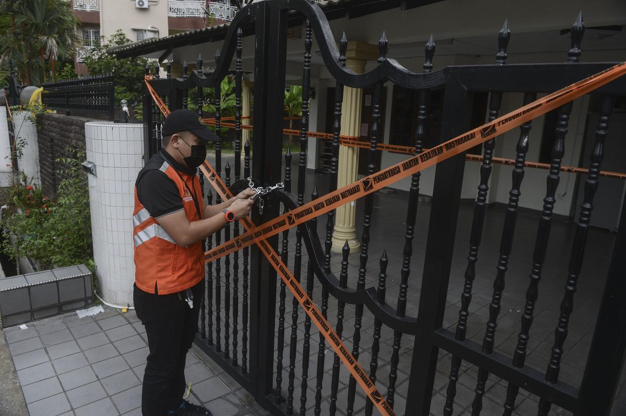 Enforcement officers from the social welfare department tape over the gate of an unregistered home in Kuala Lumpur following a video which went viral on social media on a disabled girl who was believed to have been abused by the home's founder. Photo: Bernama         