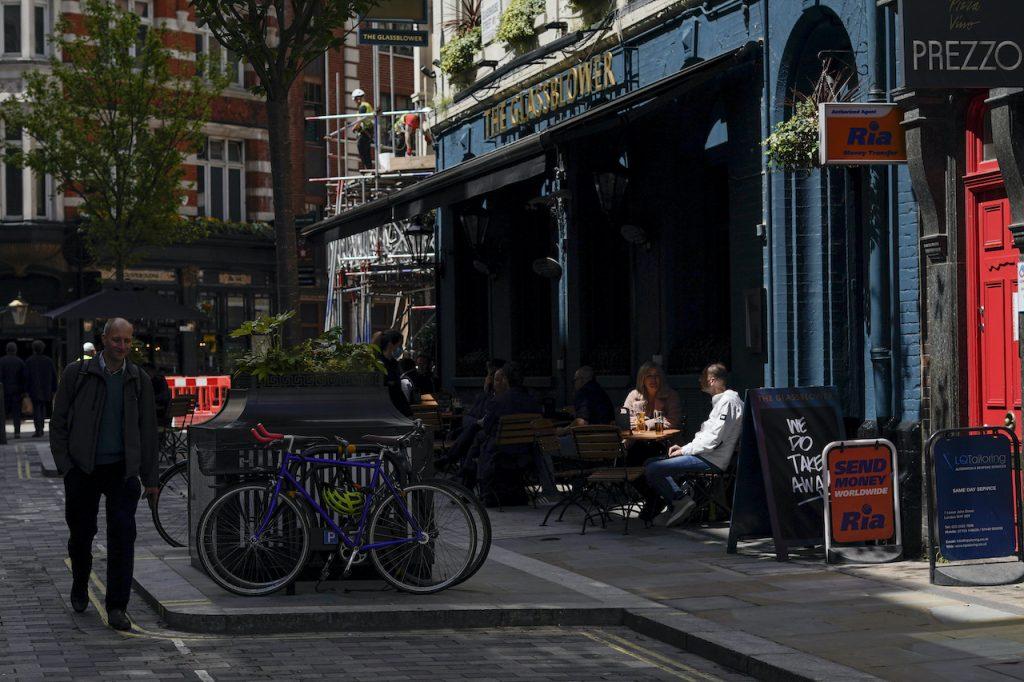 People sit at tables outside a pub in Soho, as pubs, cafes and restaurants in England reopen indoors under the latest easing of the coronavirus lockdown in London, May 18. Pubs, clubs and restaurants were closed for most of last year, but the total volume of alcohol sold stayed the same, suggesting people switched to drinking at home instead. Photo: AP