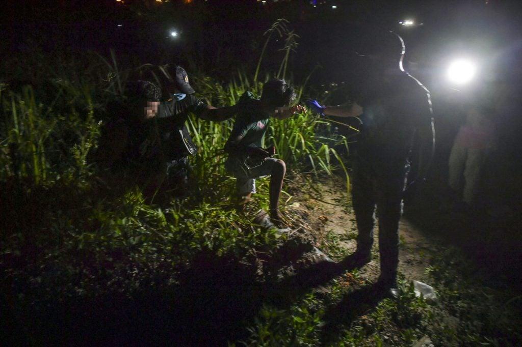 Officers from the immigration department detain a migrant worker during a raid in Cyberjaya last month. Photo: Bernama