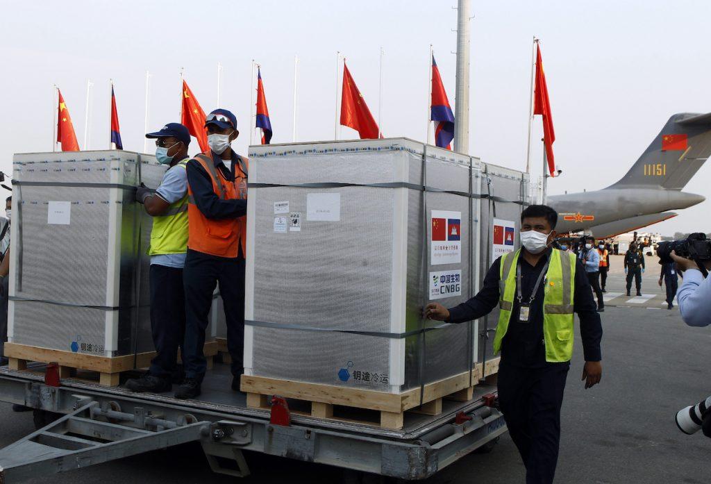 Workers pull boxes loaded with Covid-19 vaccines from China at Phnom Penh International Airport, in Phnom Penh, Cambodia, in this Feb 7 file photo. China has promised billions of dollars in aid, medical equipment and vaccines to countries around the world in recent months as it brought domestic outbreaks under control. Photo: AP