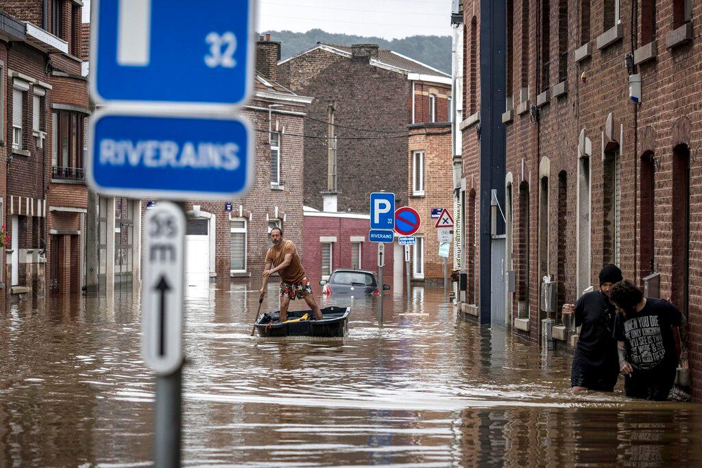 A man rows a boat down a residential street after flooding in Angleur, province of Liege, Belgium, July 16. Photo: AP