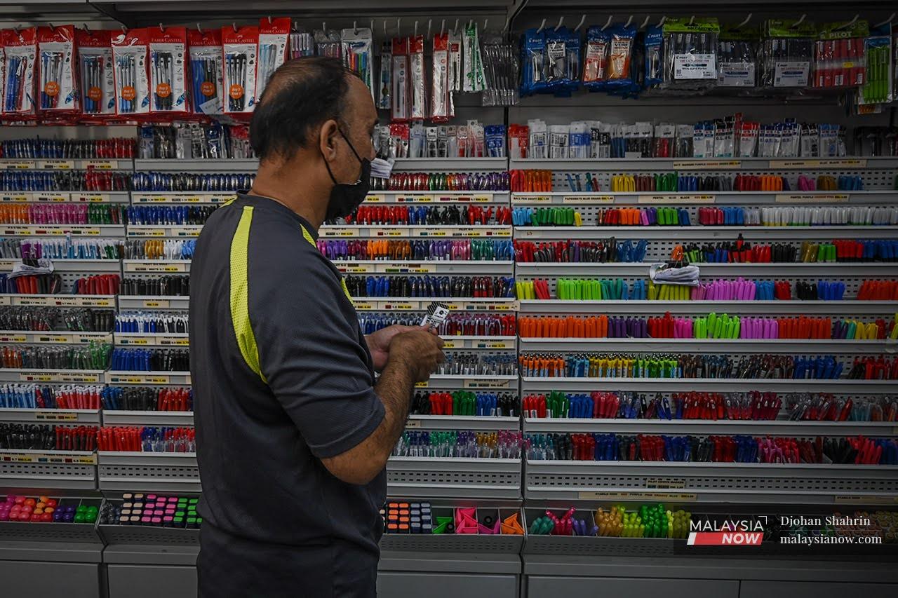 A customer makes a selection of stationery at a shop in Kuala Lumpur after the government gave the green light for such stores to open throughout the duration of the National Recovery Plan.