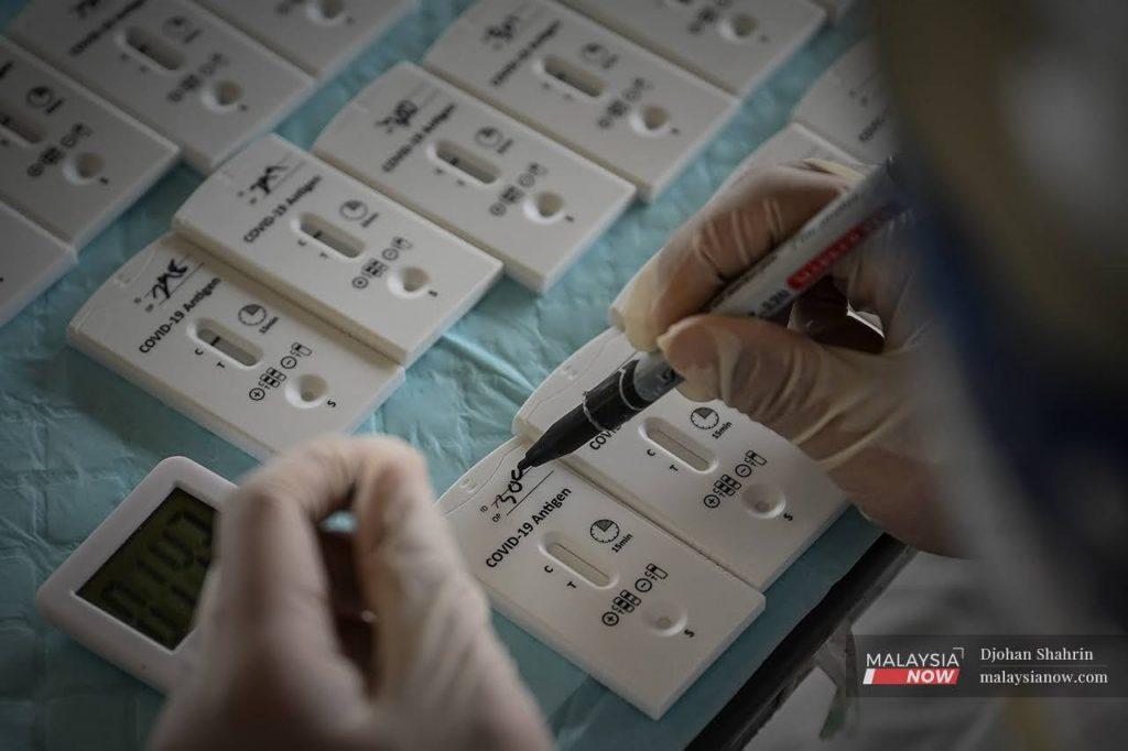 Petugas kesihatan menggunakan kit antigen untuk mengesan jangkitan Covid-19.