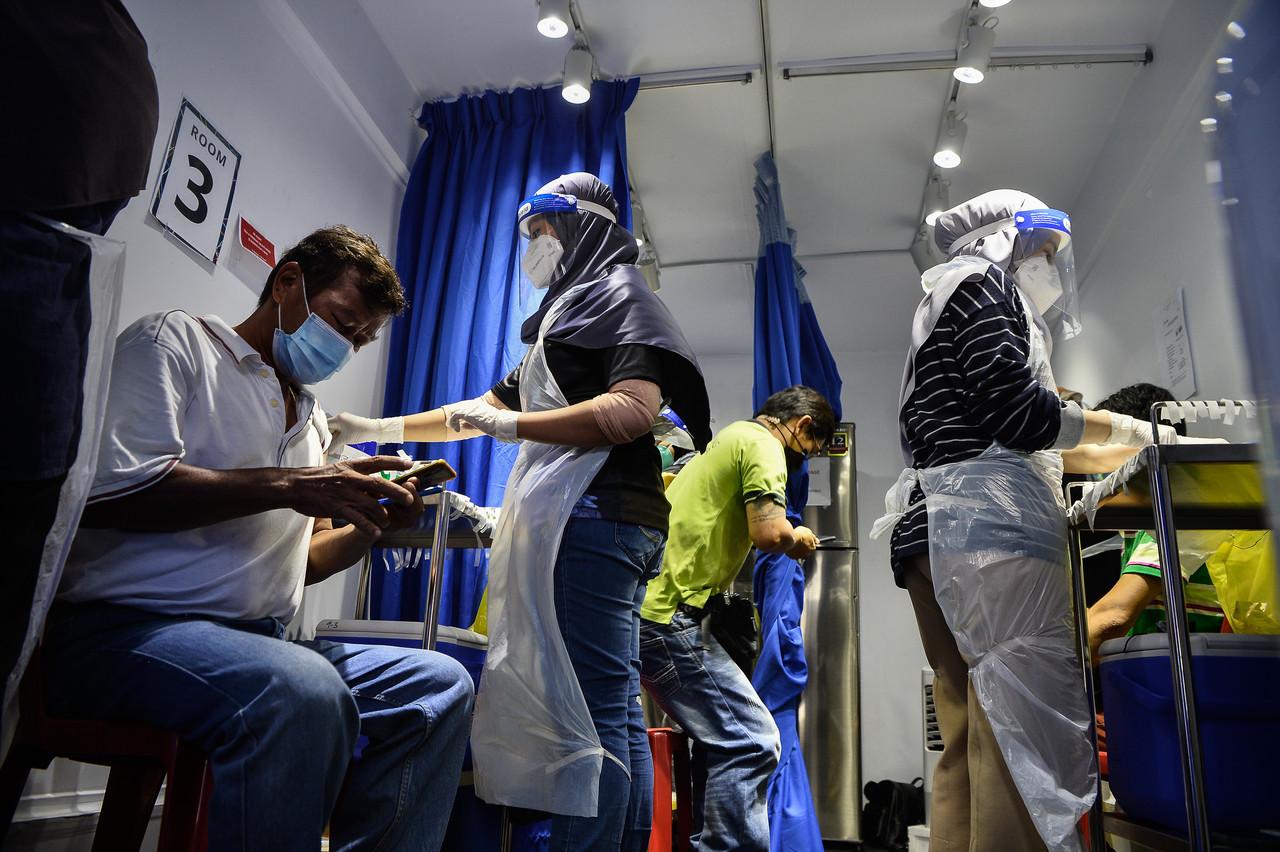 Medical workers administer shots of Covid-19 vaccine to budget hotel workers under the vaccination programme for hospitality industry workers and the Malaysian Budget Hotel Association in Kuala Lumpur. Photo: Bernama