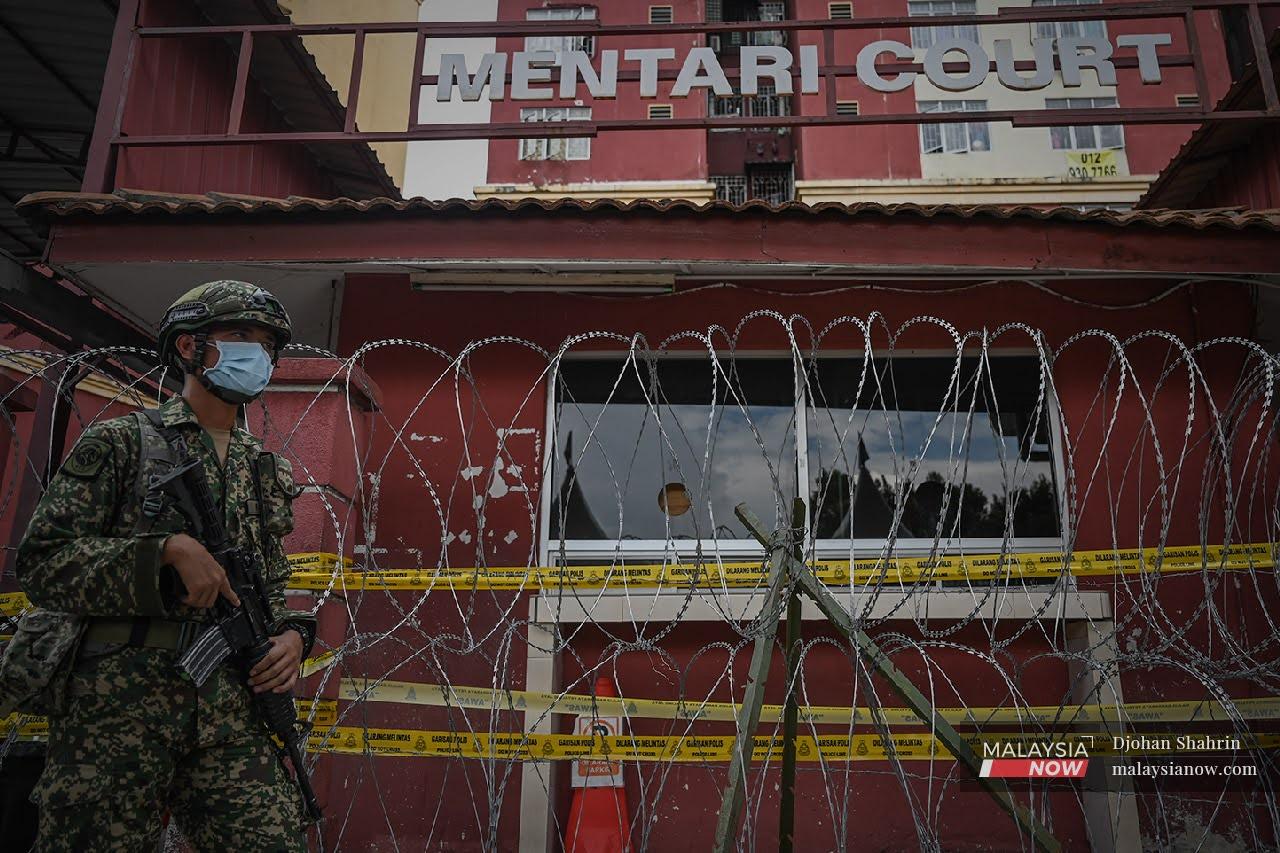A soldier monitors the Mentari Court flats in Petaling Jaya, Selangor, which were recently placed under enhanced movement control order following a spike in cases in the area.