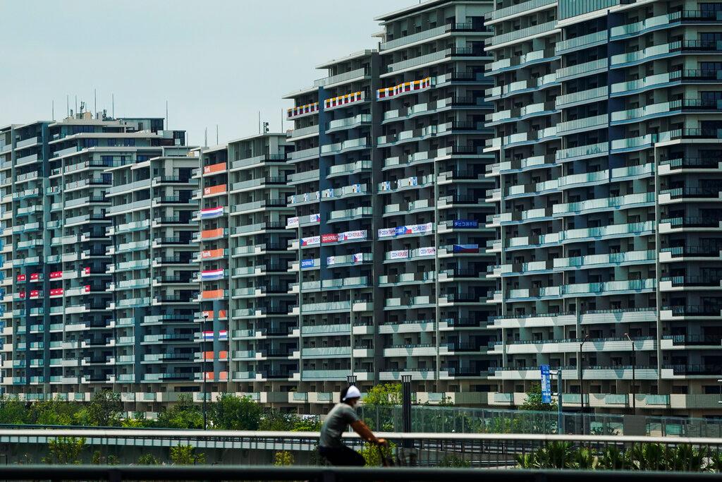 A man rides his bike near the athlete's village for the 2020 Summer Olympics and Paralympics, in Tokyo, July 15. Photo: AP