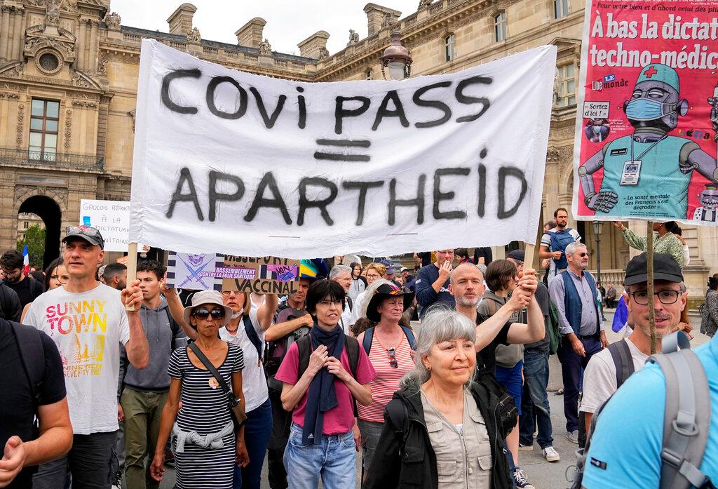 Anti-vaccine protesters march with a banner during a rally in Paris, July 17. Photo: AP