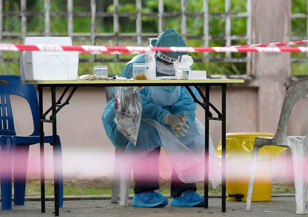 Petugas kesihatan berehat seketika  selepas melakukan saringan Covid-19 di Klinik Kesihatan Paya Besar, Kuantan, Pahang. Gambar: Bernama