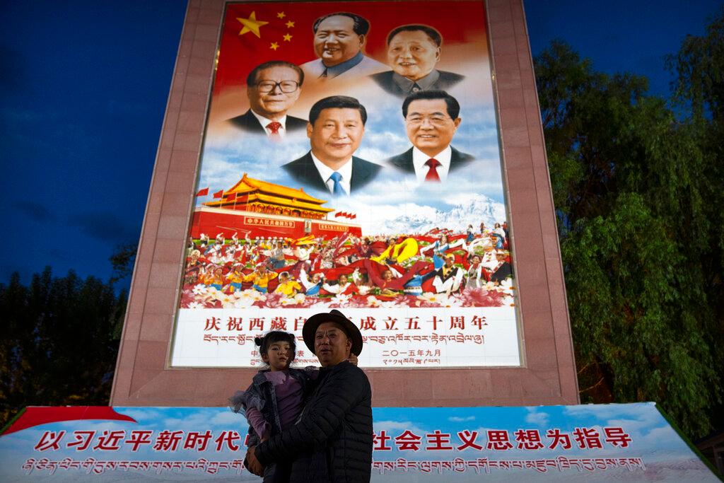 A man holds a child as they pose for a photo in front of a large mural depicting Chinese President Xi Jinping (bottom centre) and other Chinese leaders at a public square at the base of the Potala Palace in Lhasa in western China's Tibet Autonomous Region on June 1. Xi has made a rare visit to Tibet as authorities tighten controls over the Himalayan region’s traditional Buddhist culture, accompanied by an accelerated drive for economic development and modernised infrastructure. Photo: AP