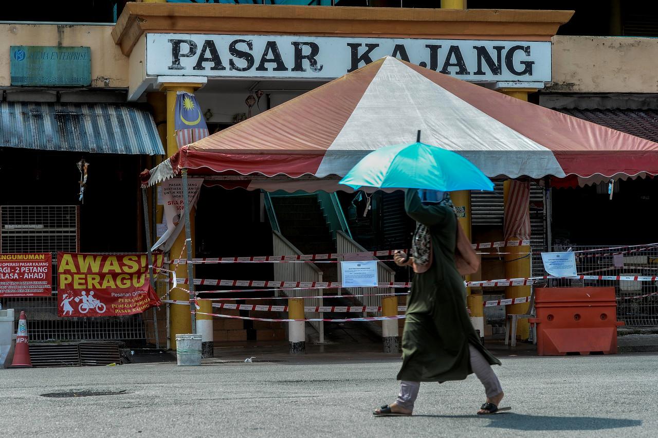 A woman walks past the Kajang market which has been closed until Aug 2 for sanitisation to curb the spread of Covid-19. Photo: Bernama