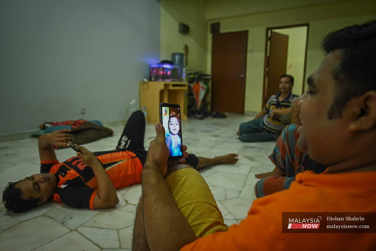 Mamun Miah, 35 berbual dengan anaknya yang berada di Bangladesh, mereka menghabiskan waktu di rumah bertemankan telefon bimbit masing-masing bagi menghilangkan kebosanan tidak bekerja sepanjang PKP 3.0.