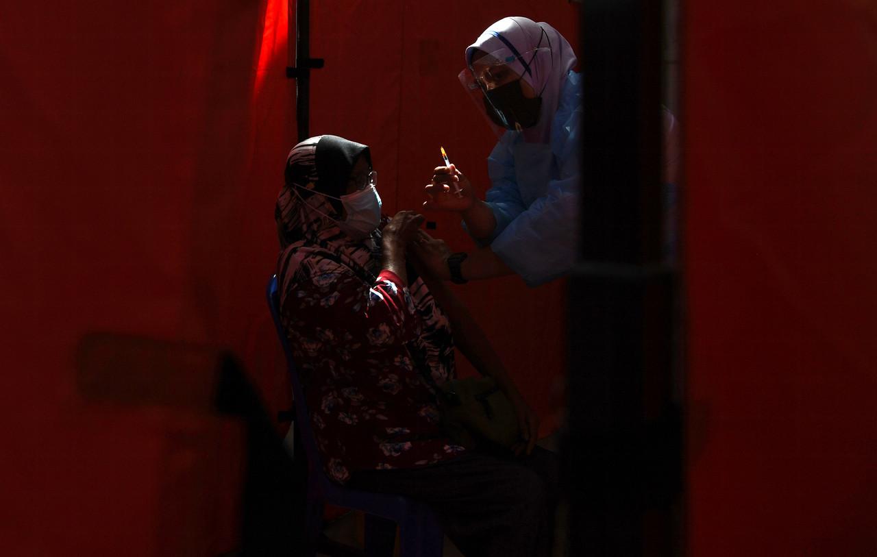 A nurse shows a recipient a syringe of Covid-19 vaccine at the vaccination centre at Dewan Majlis Perbandaran Temerloh. Photo: Bernama