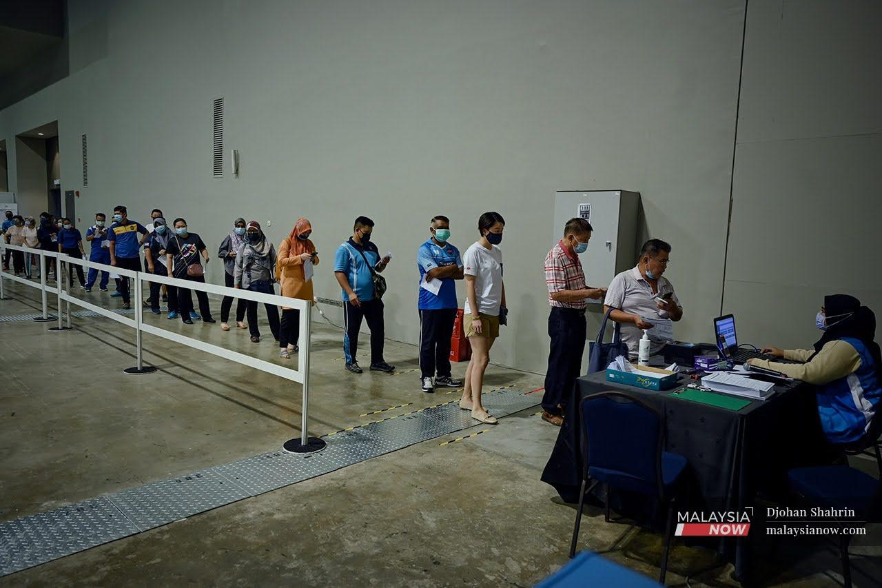 Orang ramai yang hadir beratur memasuki dewan sebelum menerima vaksin Sinovac di Malaysia International Trade and Exhibition Centre (Mitec), Jalan Dutamas.