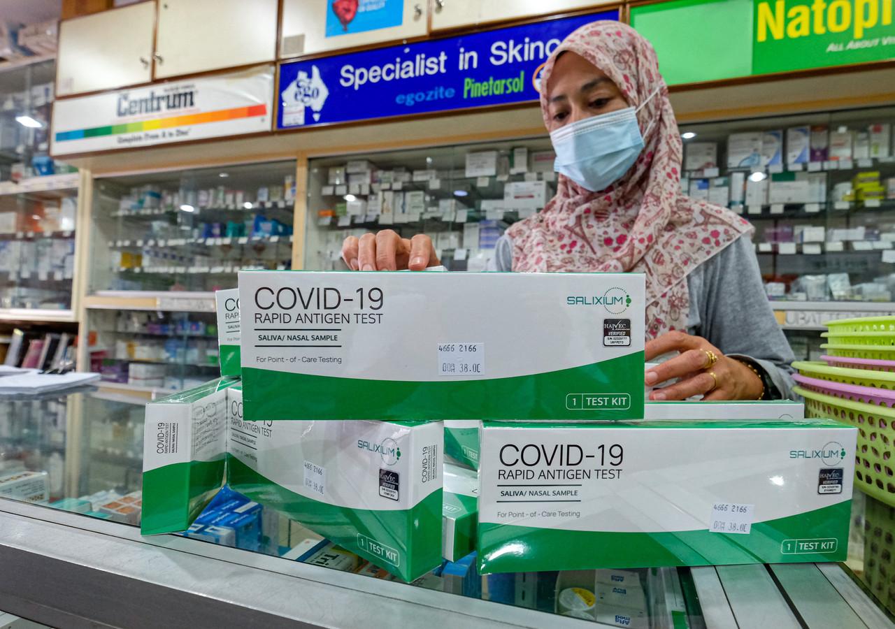Pembantu  farmasi menyusun kit ujian kendiri iaitu buatan Malaysia yang kini boleh dibeli di farmasi.