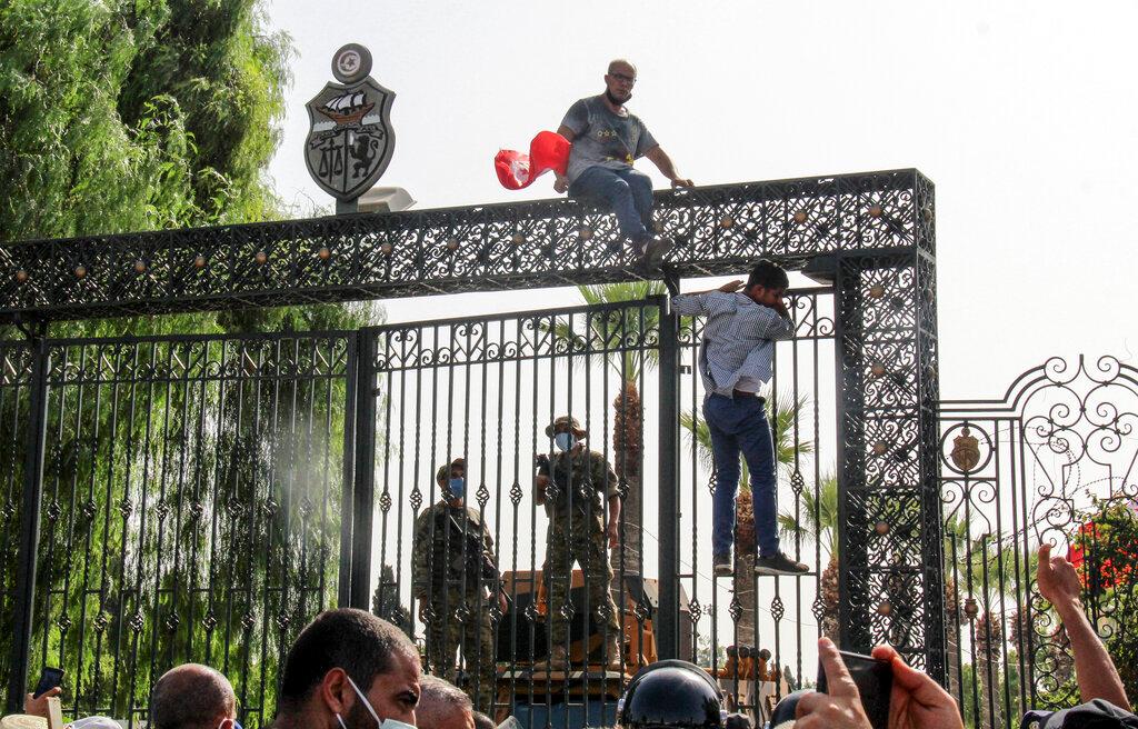 Tunisian soldiers guard the main entrance of the parliament as demonstrators gather outside the the gate in Tunis, Tunisia, July 26. Photo: AP