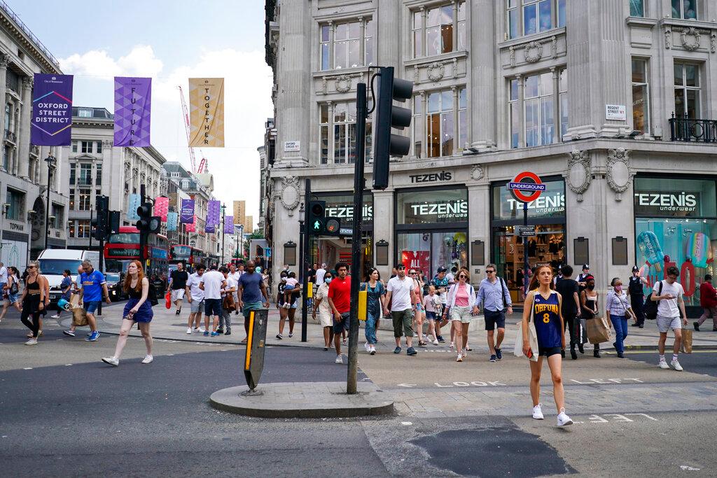People walk in Oxford Circus, in London, July 19. Recorded infection rates across the UK have dropped for seven consecutive days with a fall of nearly 50%. Photo: AP