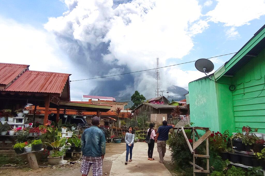 People watch as Mount Sinabung spews volcanic materials during an eruption in Karo, North Sumatra, Indonesia, July 28. Photo: AP