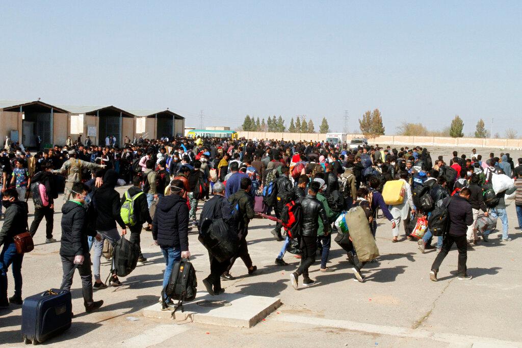 In this March 18, 2020 file photo, thousands of Afghan refugees enter Afghanistan at the Islam Qala border crossing with Iran, in the western Herat province. Official sources say more than 27,000 people, not all of them Afghans, have been intercepted crossing the border with Iran since the start of the year. Photo: AP