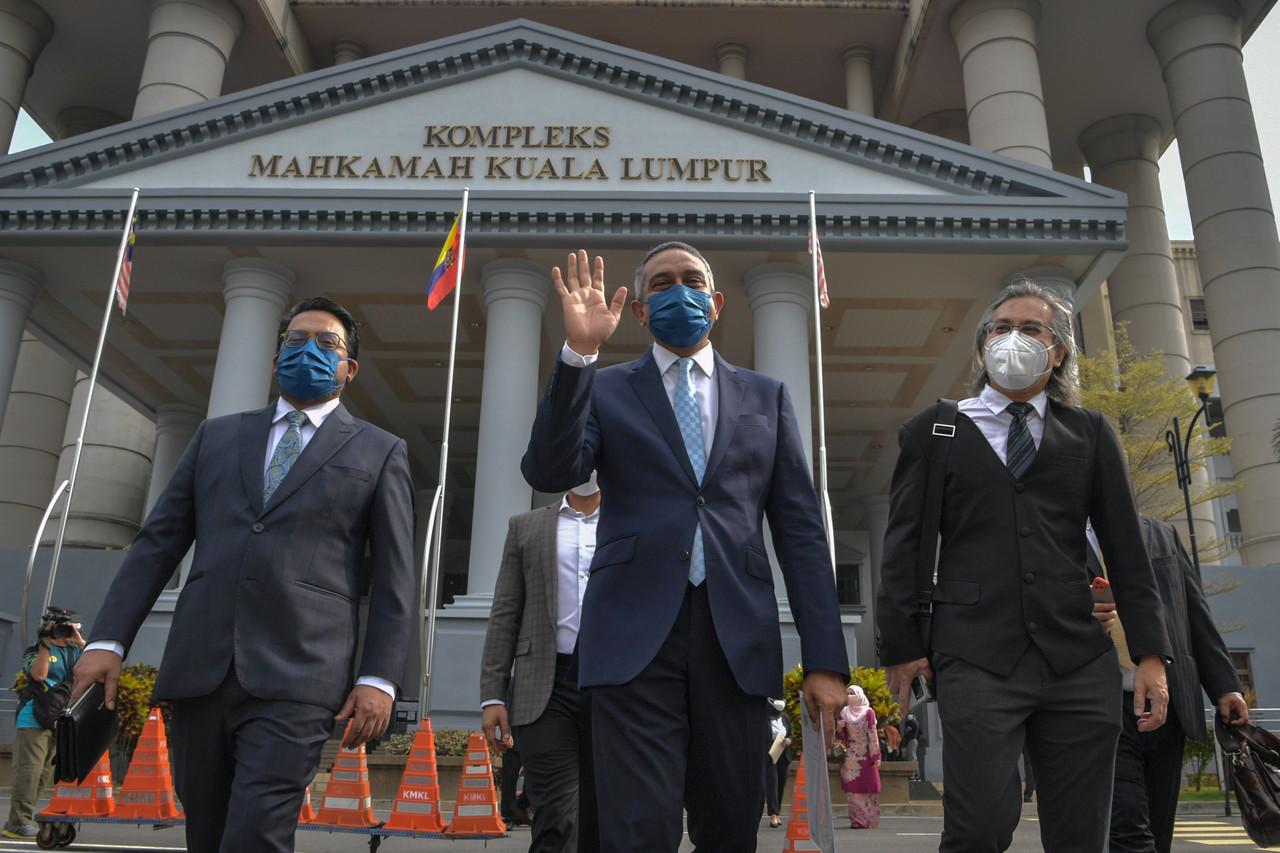 Umno legal adviser Mohd Hafarizam Harun (centre) waves as he leaves the Sessions Court in Kuala Lumpur today. Photo: Bernama