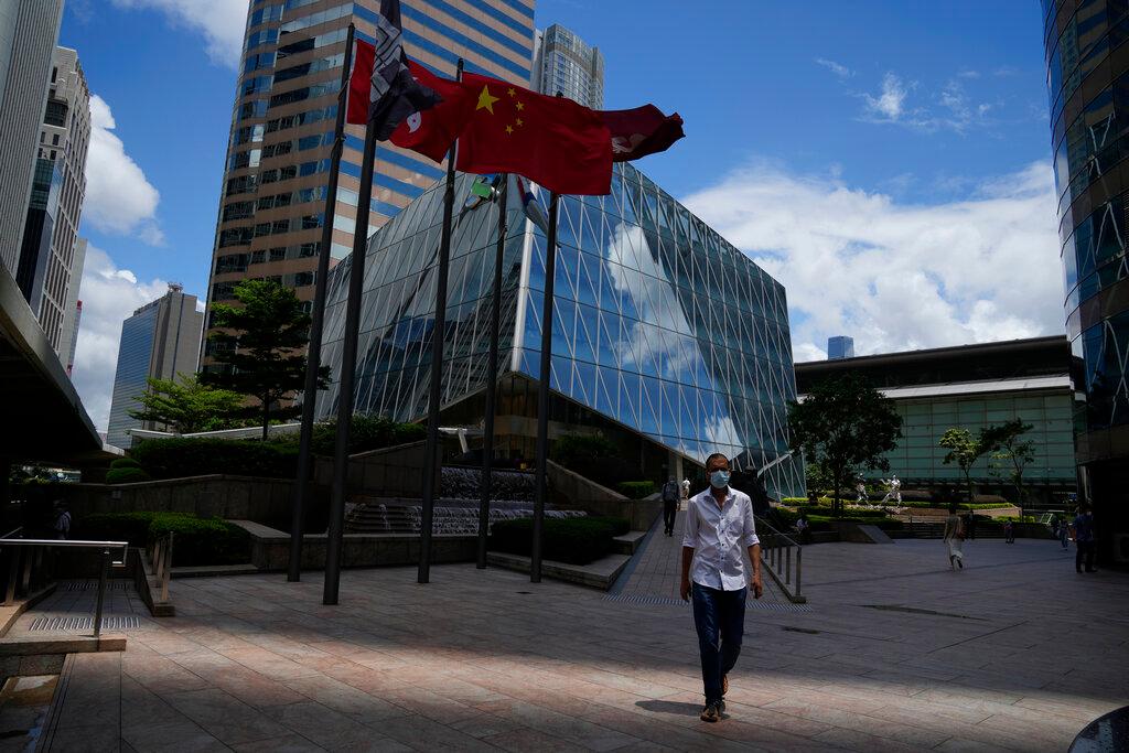 A man walks under the Chinese and Hong Kong flags outside the Hong Kong Exchange Square, in this July 7 file photo. Under a recently passed law in the former British colony, it is illegal to insult the Chinese national anthem. Photo: AP