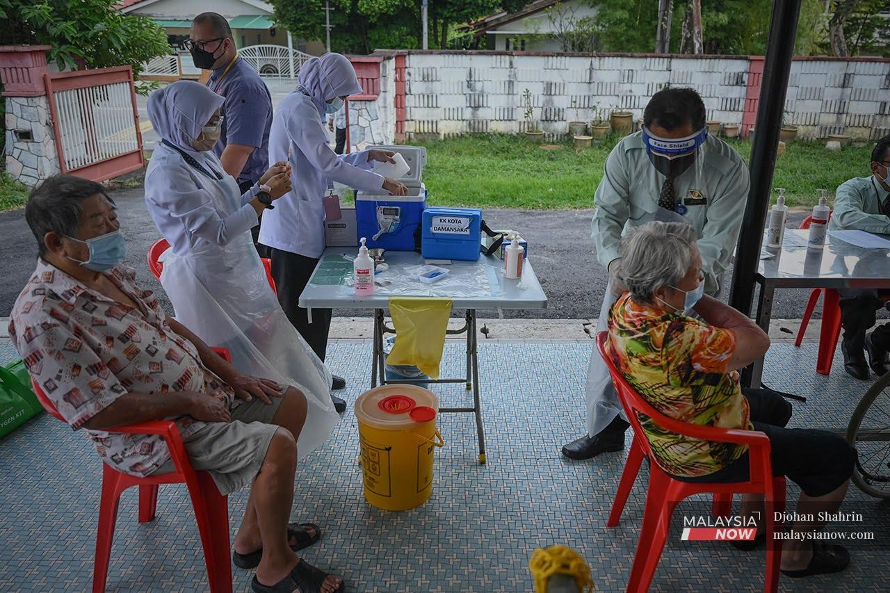Health workers prepare shots of Covid-19 vaccine to be administered to residents during a house-to-house visit at Pertubuhan Kebajikan Warga Emas Kenangan Budi Kuala Lumpur in Petaling Jaya.