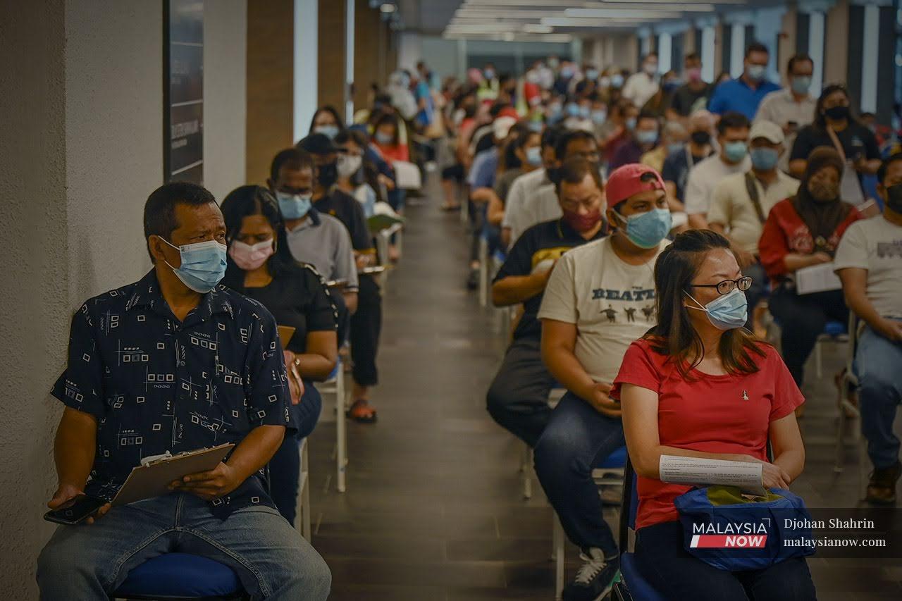 People wait for their turn to be vaccinated against Covid-19 at the vaccination centre at Axiata Arena Bukit Jalil in Kuala Lumpur.