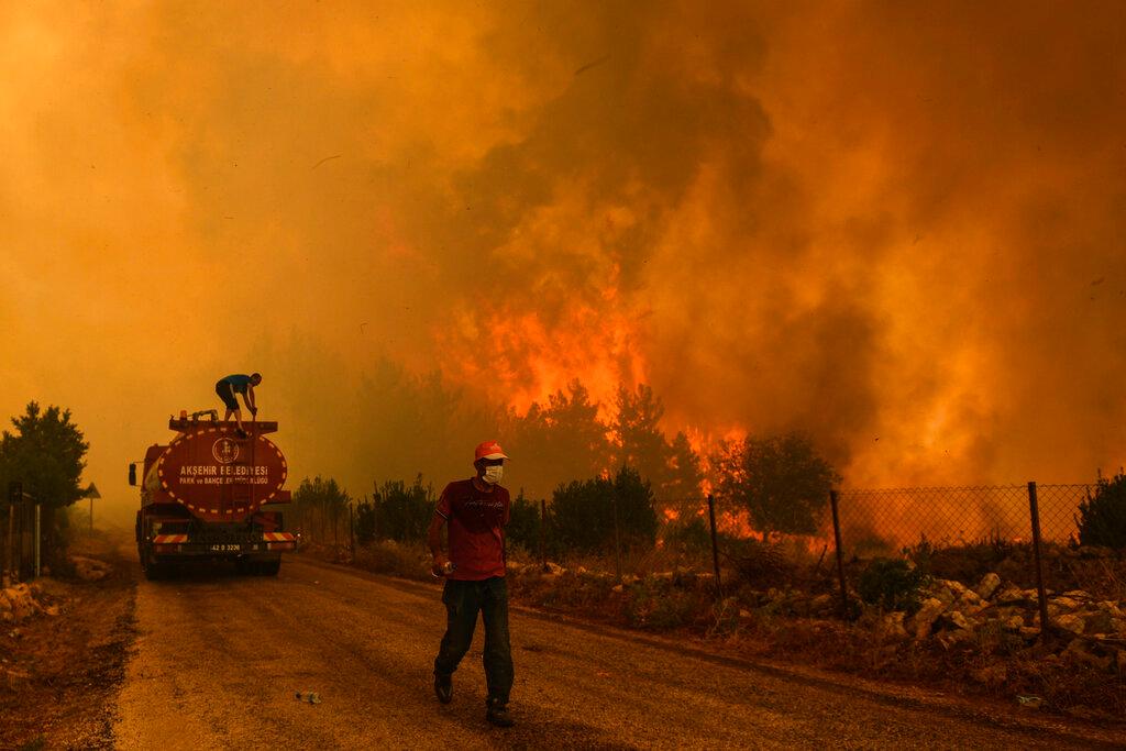 Men work to put out a fire at Sirtkoy village, near Manavgat, Antalya, Turkey, Aug 1. Photo: AP