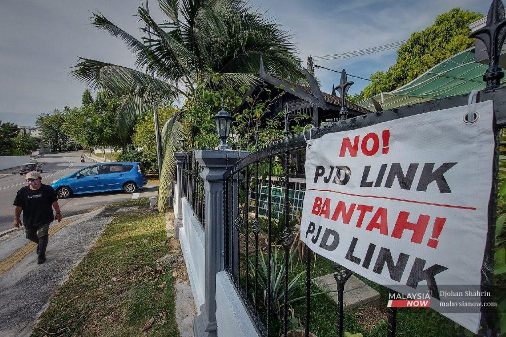 A small banner protesting the construction of the PJD Link hangs from the fence of a house in Section 17, Petaling Jaya.