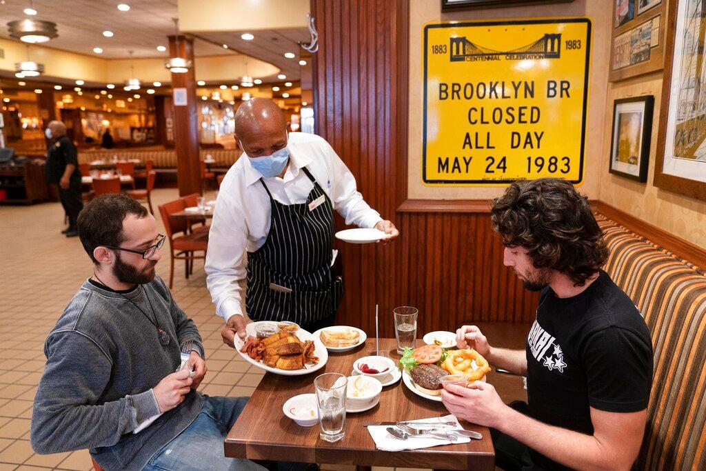 In this Sept 30, 2020, file photo, a waiter serves lunch to customers at a restaurant in New York. New York City will soon require proof of Covid-19 vaccinations for anyone who wants to dine indoors at a restaurant, see a performance or go to the gym, making it the first big city in the US to impose such restrictions. Photo: AP