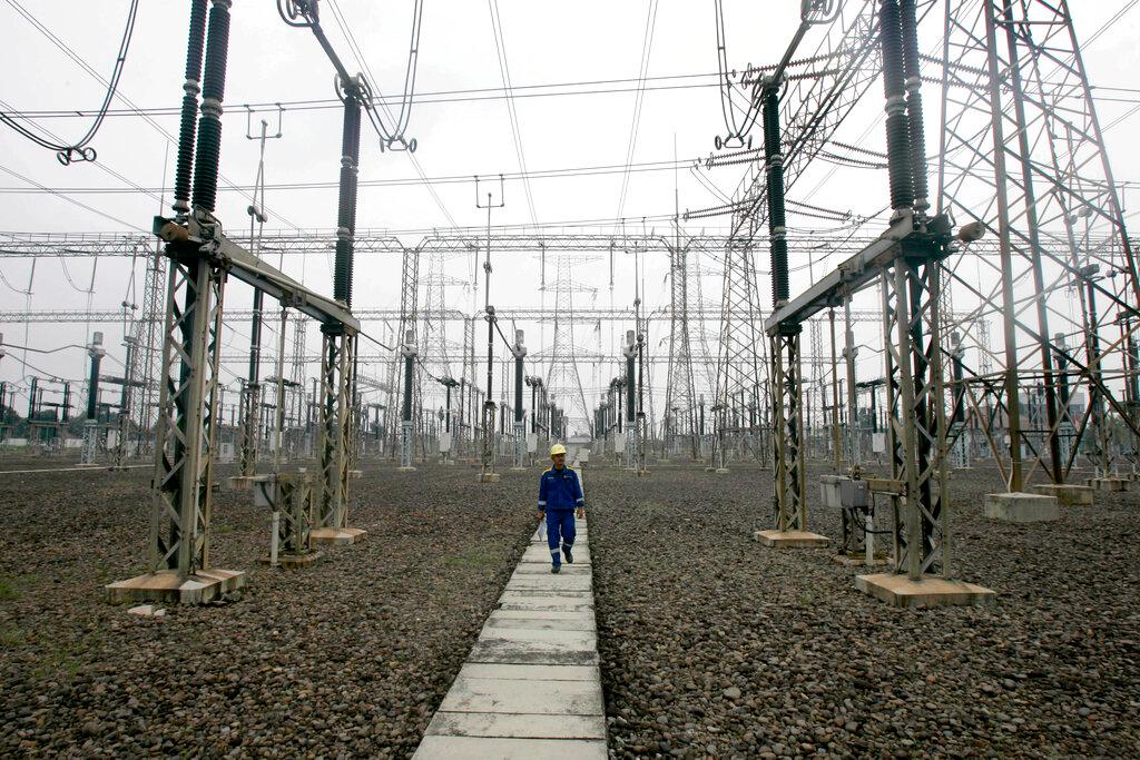A technician walks under power lines at a power plant in Jakarta, Indonesia, Oct 5, 2010. Indonesia aims to have 23% of its energy from renewable sources by 2025. Photo: AP