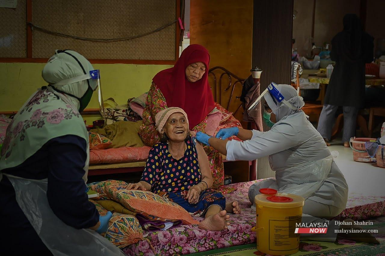 Team Outreach Program Imunisasi Covid-19 Kebangsaan Sabak Bernam memberikan vaksinasi kepada seorang warga emas di Sungai Besar, Kuala Selangor.