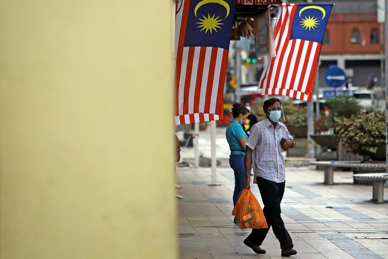 Pedestrians in Seremban comply with the SOP on the use of face masks in public areas under Phase One of the National Recovery Plan. Photo: Bernama