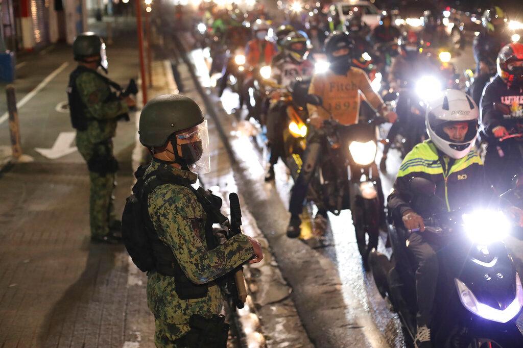 Police officers inspect motorcycle riders at a checkpoint during a stricter lockdown as a precaution against the spread of the coronavirus at the outskirts of Marikina City, Philippines, Aug 6. Photo: AP