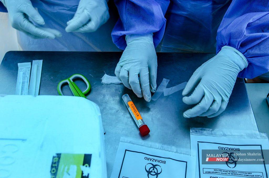 Petugas kesihatan mengambil sampel ujian swab untuk saringan Covid-19.