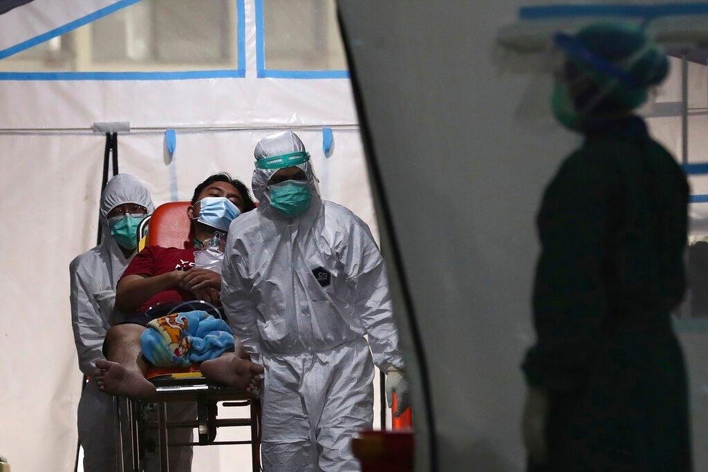 Petugas kesihatan menggunakan katil beroda untuk memindahkan seorang lelaki dari wad kecemasan Covid-19 di Hospital Cengkareng di Jakarta, Indonesia. Gambar: AP