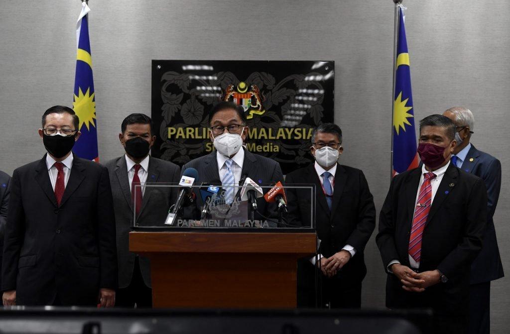 Pemimpin Pakatan Harapan Lim Guan Eng (kiri) Mohamad Sabu (kanan) turut bersama Presiden PKR Anwar Ibrahim (tengah) ketika berucap di bangunan Parlimen pada 29 Julai. Gambar: Bernama