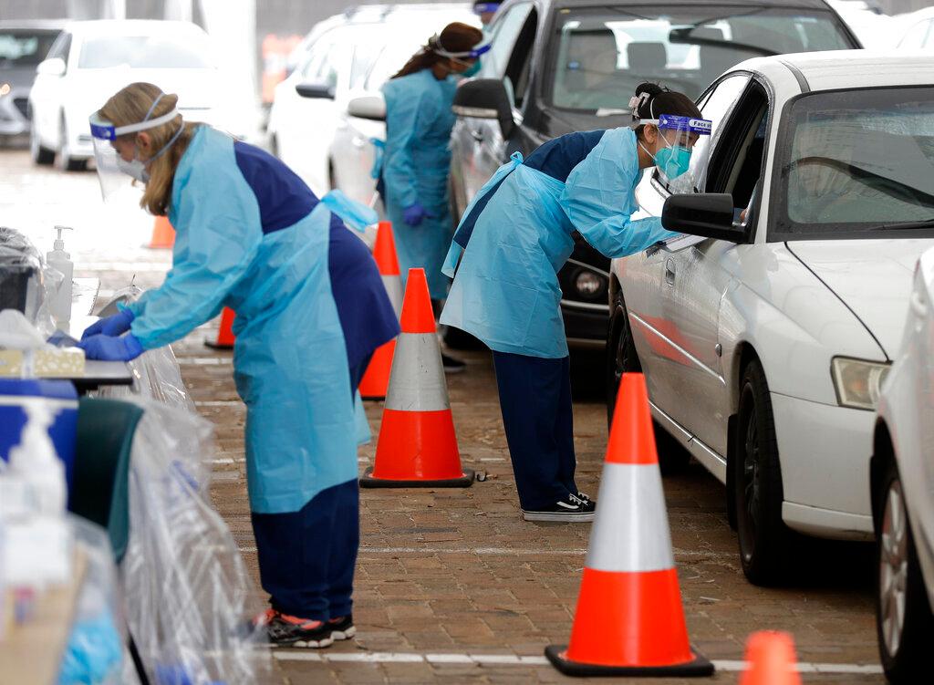 Health workers take swab samples from residents at a Covid-19 drive-thru testing site in western Sydney on Aug 4. Photo: AFP