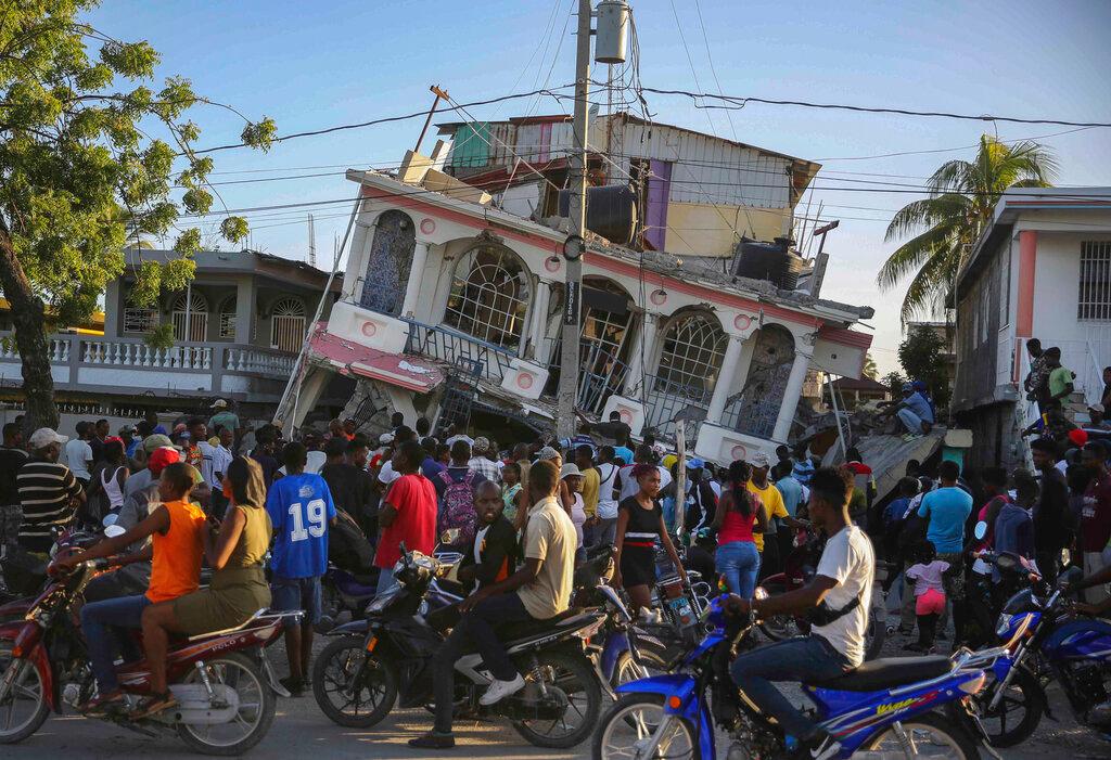 People gather outside the Petit Pas Hotel, destroyed by an earthquake in Les Cayes, Haiti, Aug 14. Photo: AP
