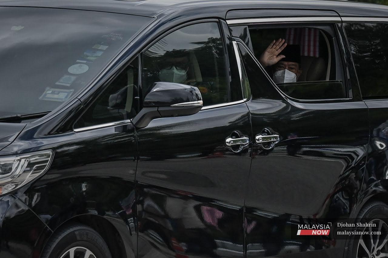 Presiden Bersatu, Muhyiddin Yassin melambaikan tangan ketika kenderaan rasmi tiba di pintu utama Istana Negara untuk mengadap Yang di-Pertuan Agong semalam.
