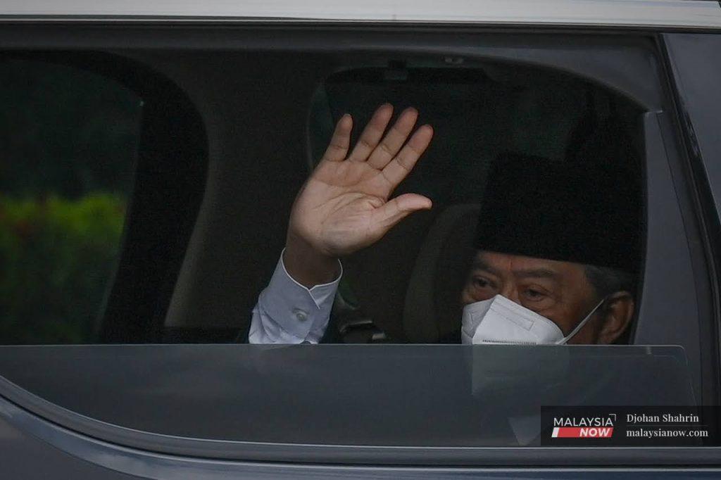 Muhyiddin Yassin melambai tangan kepada petugas media ketika beliau tiba di pintu masuk Istana Negara.