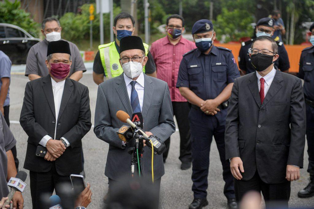 Presiden PKR Anwar Ibrahim diemani Setiausaha Agung DAP Lim Guan Eng dan Presiden Amanah Mohamad Sabu dalam sidang media di pintu masuk Istana Negara. Gambar: Bernama