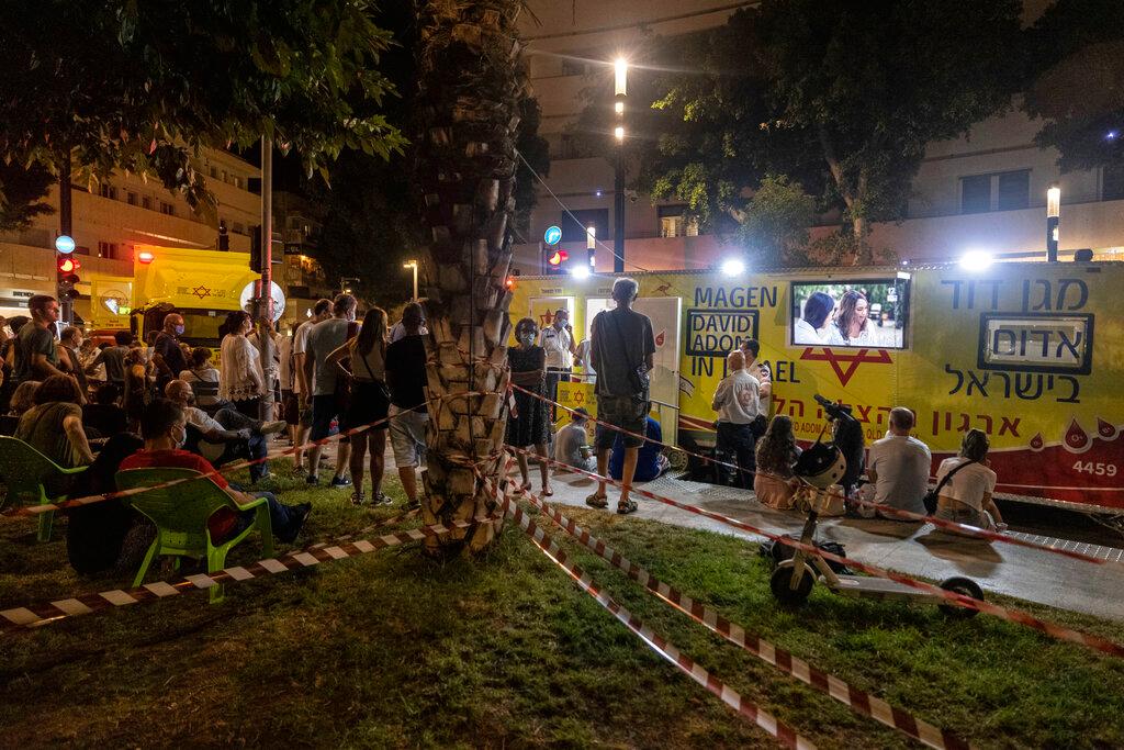 Israelis gather in Dizengoff Square to receive booster shots of the coronavirus vaccine in Tel Aviv, Israel, Aug 14. The country that had appeared to put the coronavirus pandemic behind it a few months ago after a world-leading vaccine drive is now re-imposing regulations in a bid to clamp back down on infections. Photo: AP